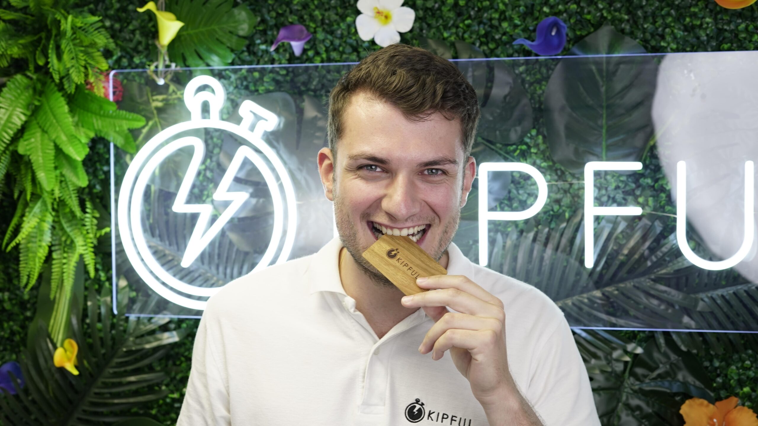 Homme souriant tenant une carte KIPFUL en bois