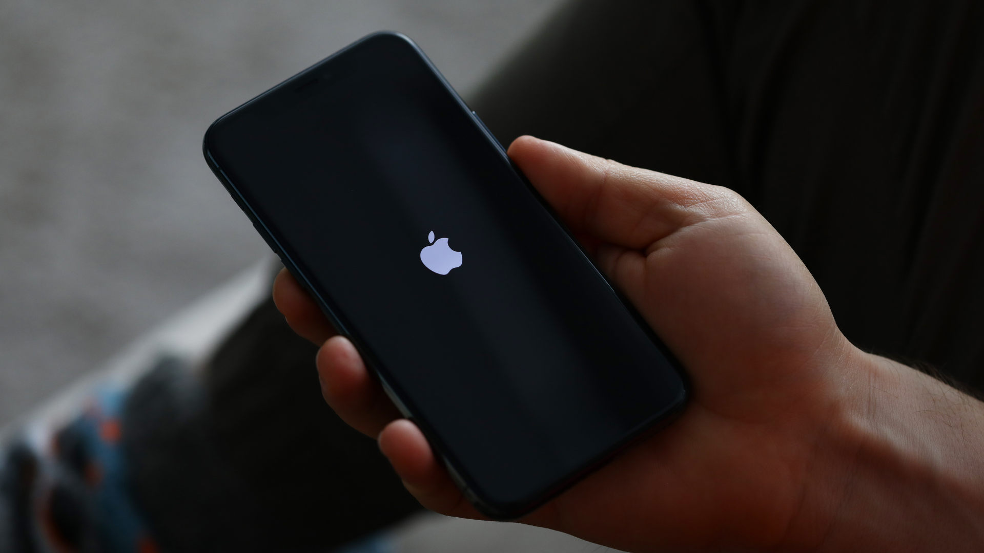 homme qui tient un iphone qui s'allume dans la main