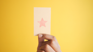 main tenant une carte estampillée d'une étoile