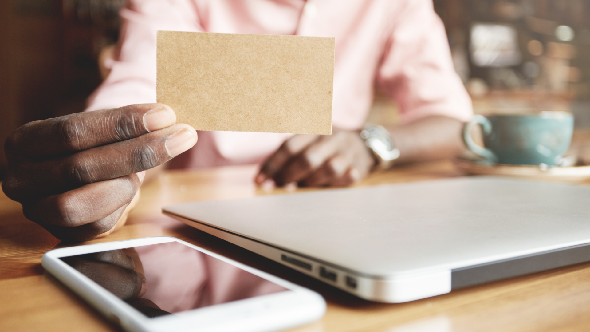 personne tenant dans sa main une carte de visite connectée